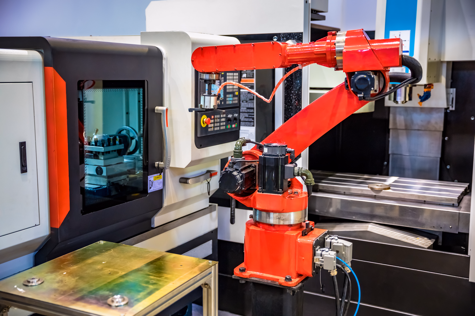 Robotic arm on manufacturing line with engineering equipment in background